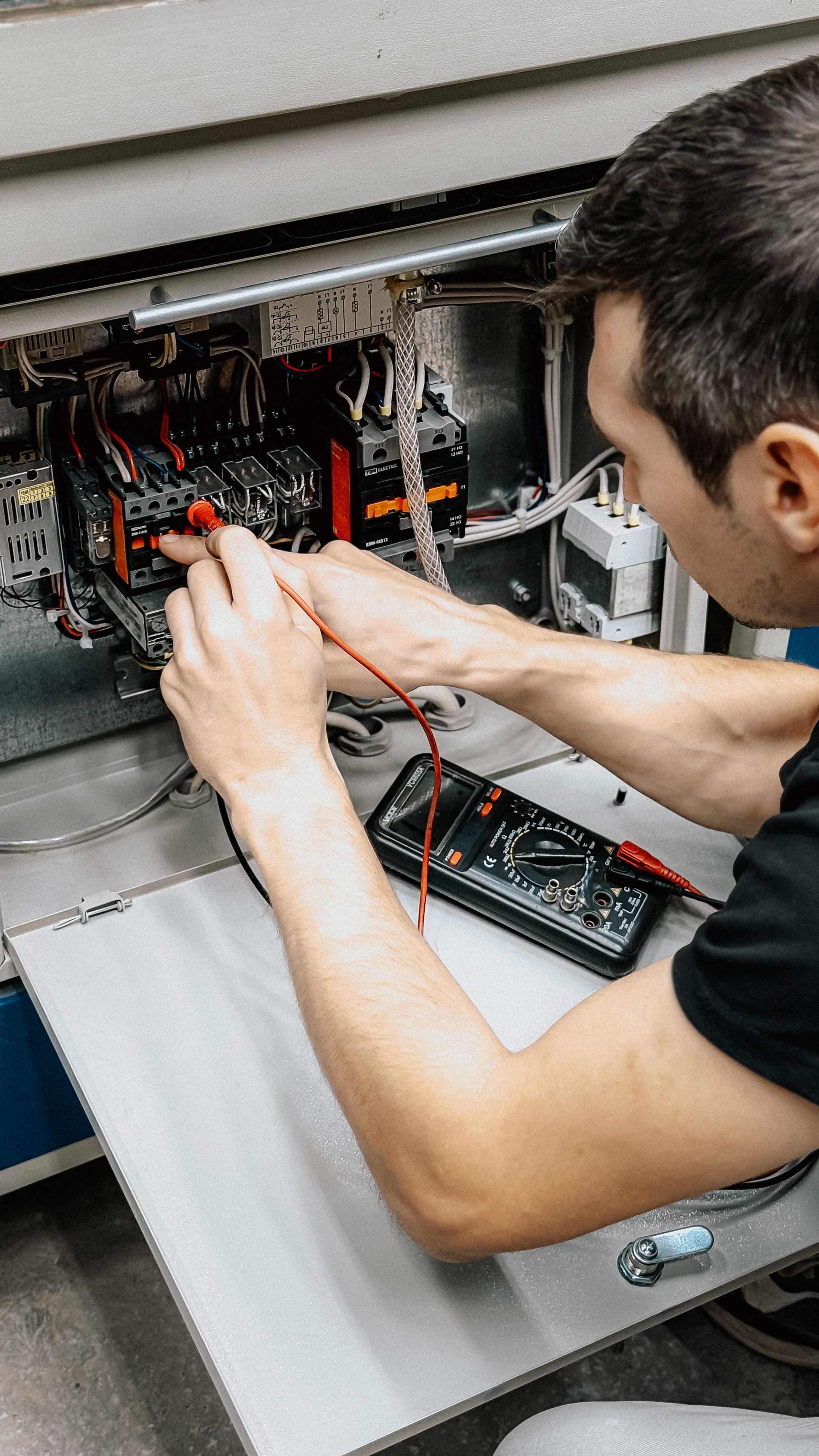 Técnico diagnosticando conexiones eléctricas con un multímetro